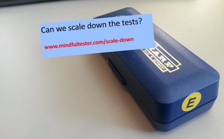 A closed box containing a mouth harmonica. Showing texts “Can we scale down the tests?” and “mindfultester.com/scale-down”!